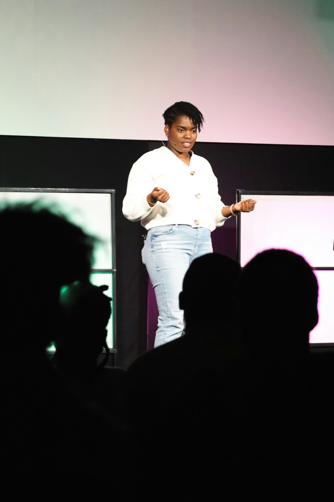 Speaker presenting on stage at a business seminar in front of an audience